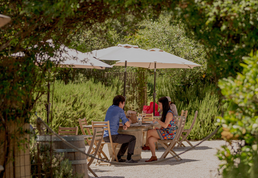 friends having lunch outside under umbrella