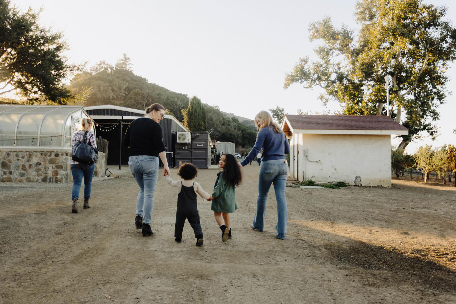 Getting Here Family with young children holding hands while walking