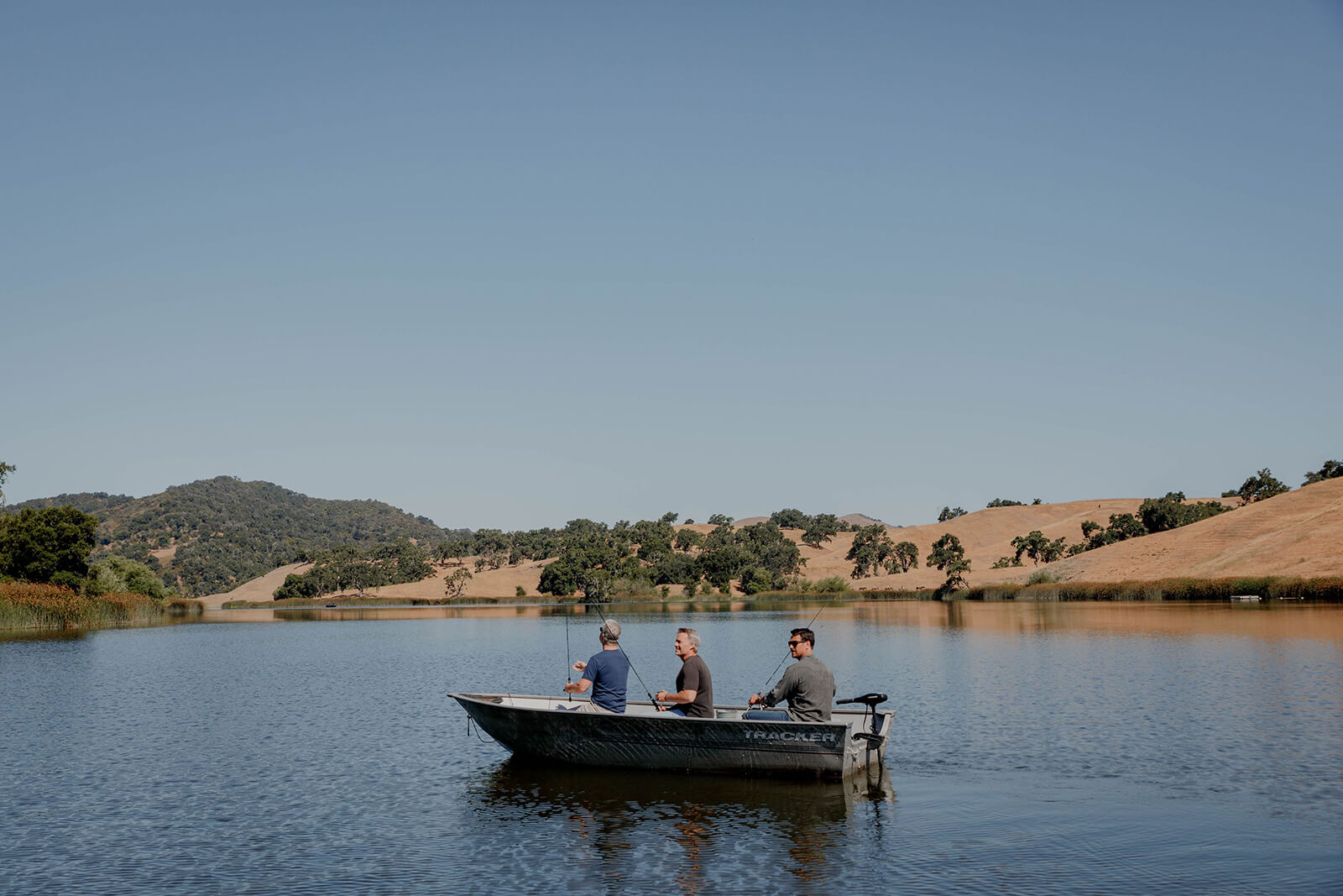 Travel and Visitor Services Three men in a fishing boat on the water in the Santa Ynez Valley